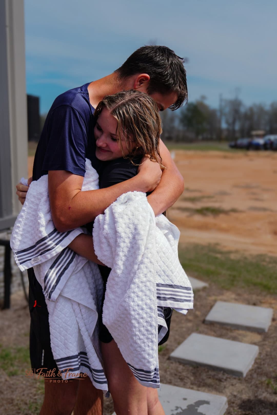 A new believer embraced after being baptized at The New